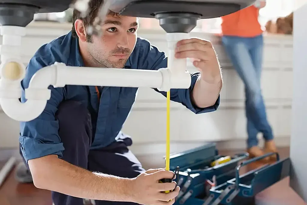 Plumber inspecting kitchen sink drain pipes, drain cleaning service in Aurora