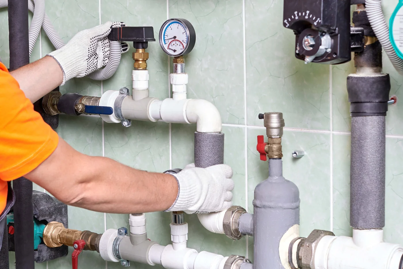 Technician servicing hydronic heating pipes and a pressure gauge, heating plumbing in Vaughan